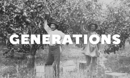 Heritage Photo of man standing by apple tree.